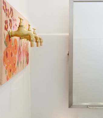 Vista lateral do bengaleiro numa casa de banho com um espelho e o lavatório de fundo